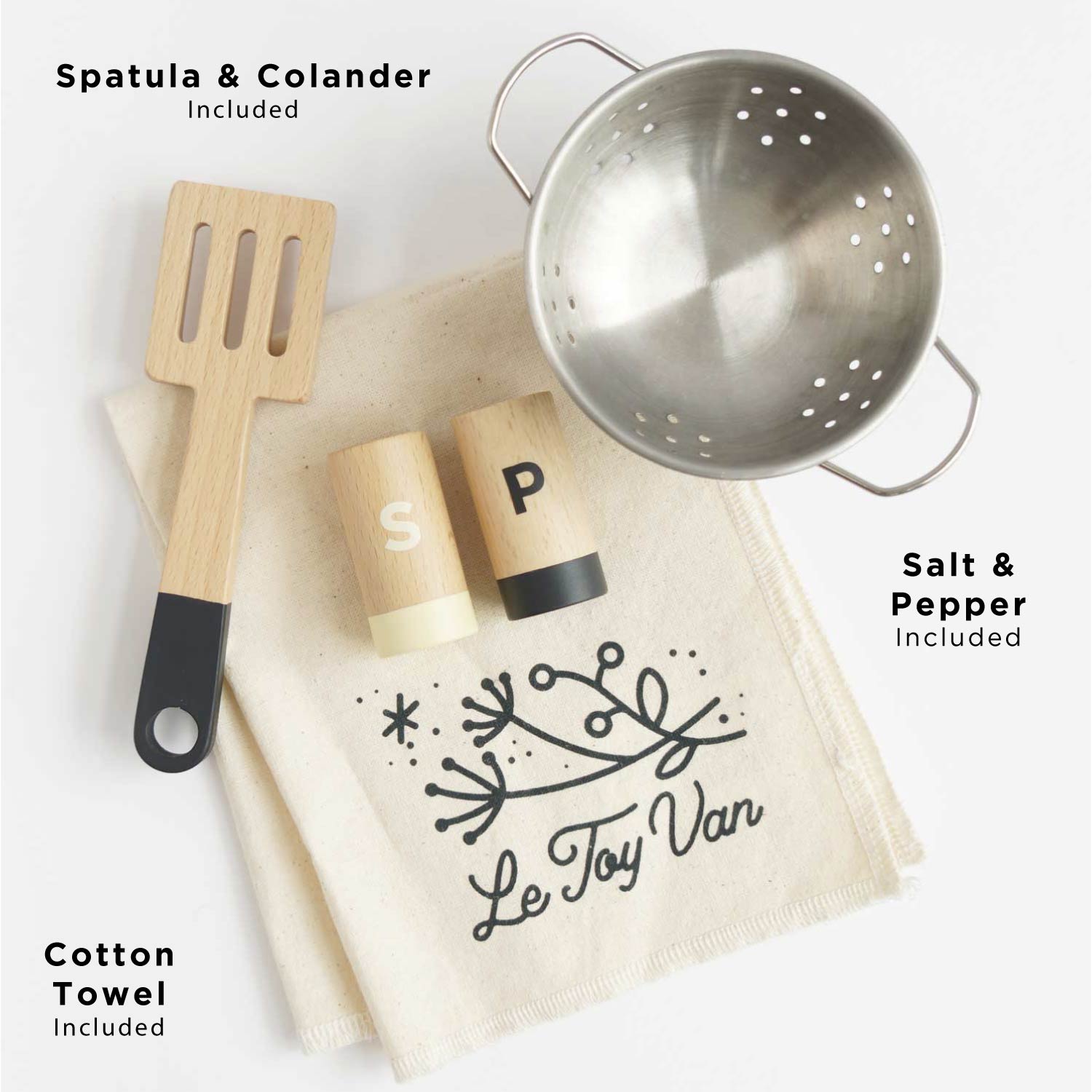 Kitchen utensils including a spatula, colander, salt and pepper shakers, and a cotton towel with 'Le Toy Van' branding on a white background.