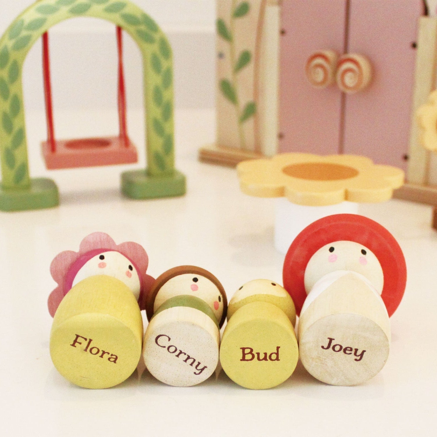 Set of wooden toy figures with colorful hats and names on a white background