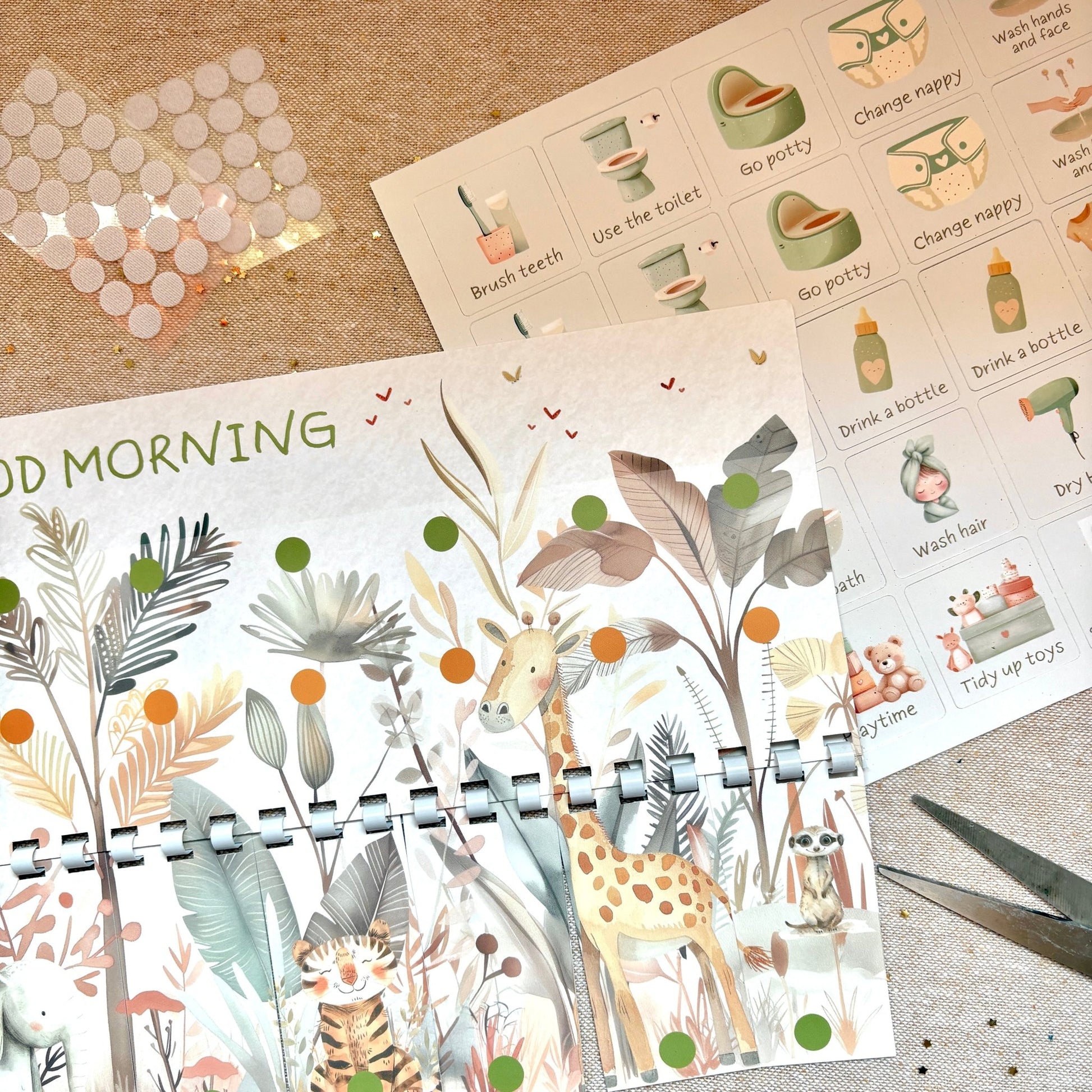 Planner with animal illustrations on a textured surface with stickers and scissors.