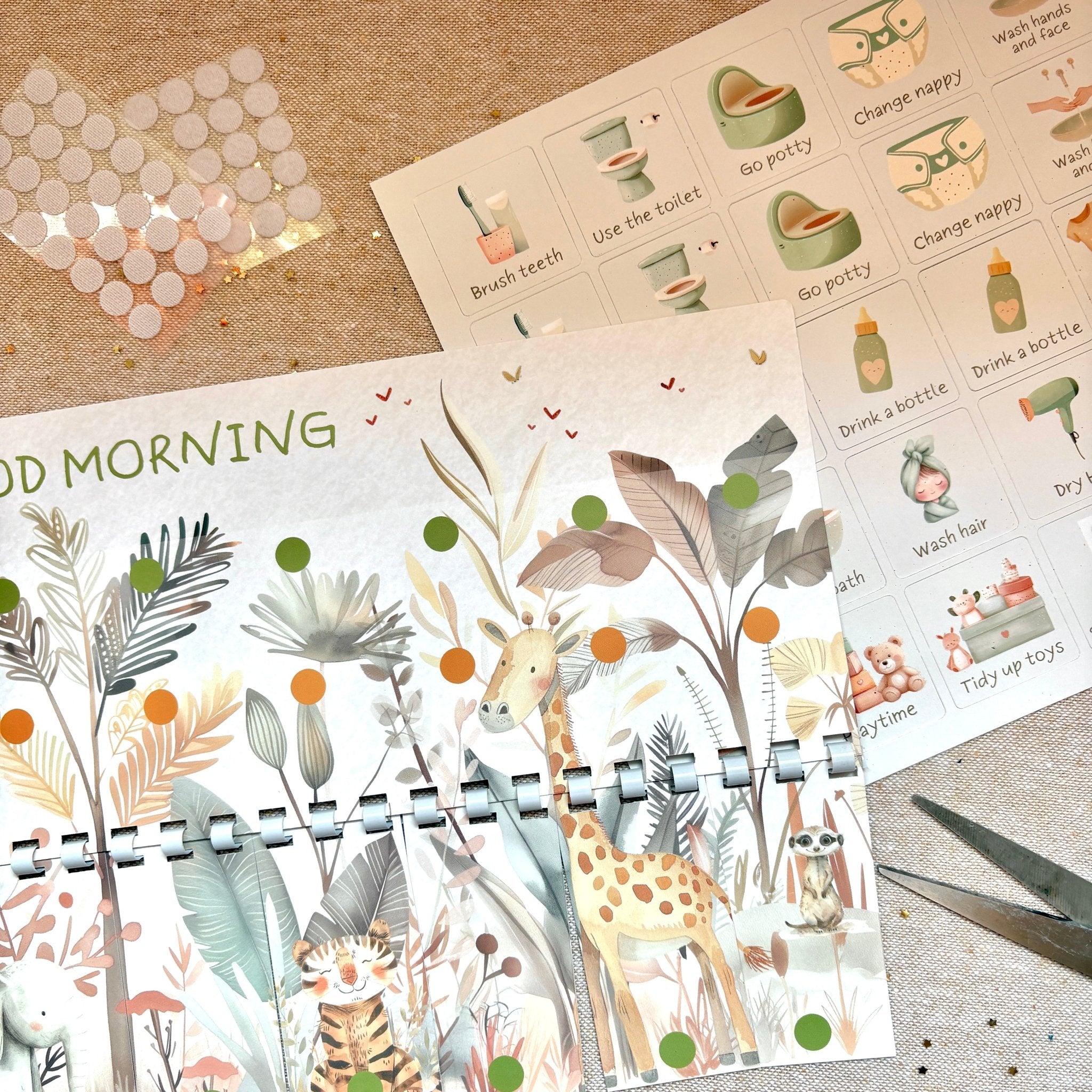 Planner with animal illustrations on a textured surface with stickers and scissors.