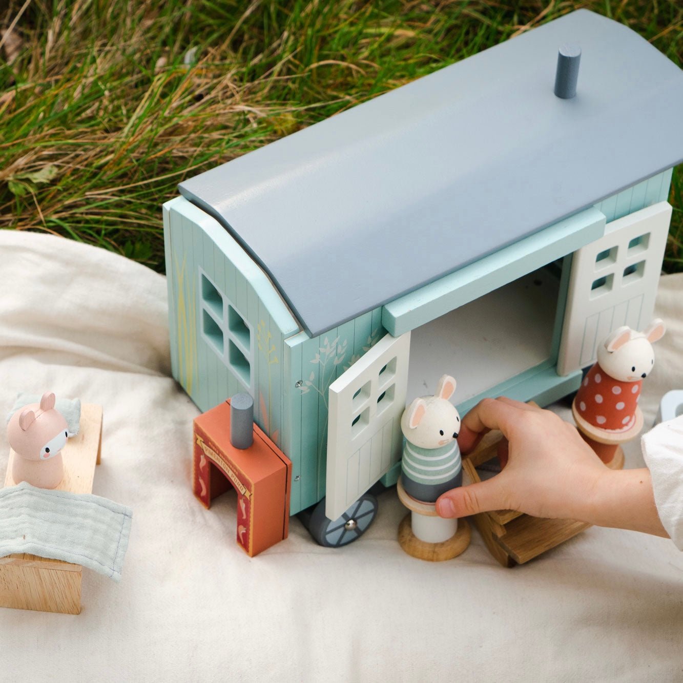 Toy house with small figures on a grassy background