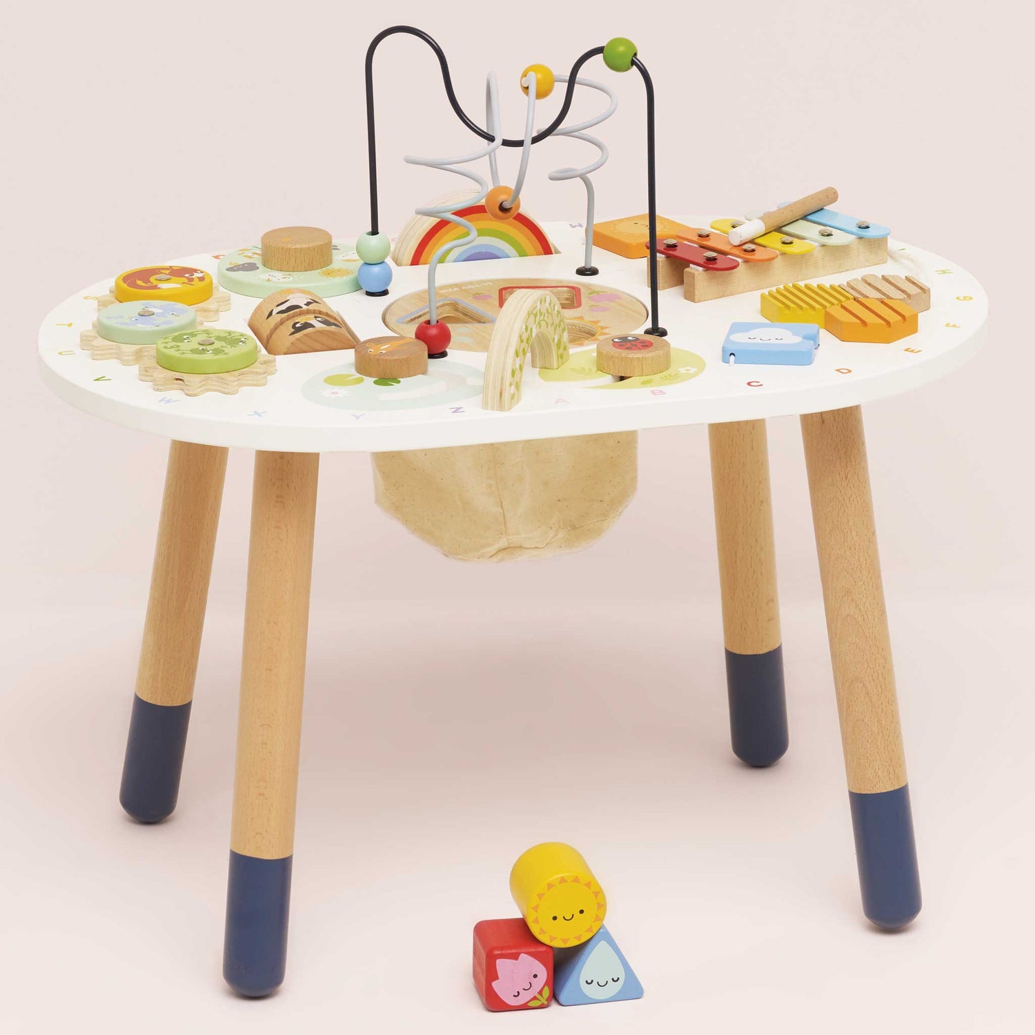 Children's activity table with various educational toys on a plain background