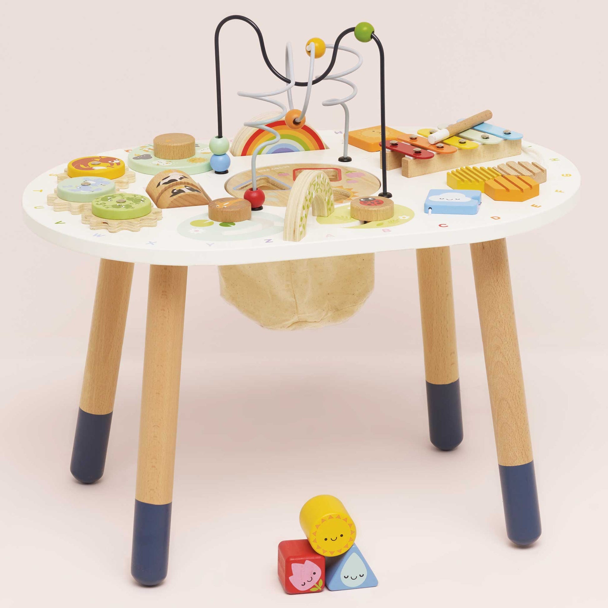 Children's activity table with various educational toys on a plain background