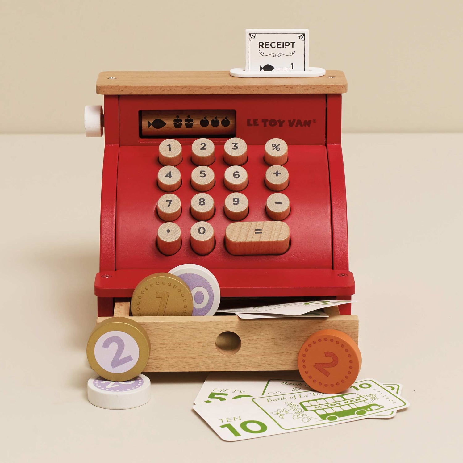 Toy cash register with wooden accents and digital display on a beige background