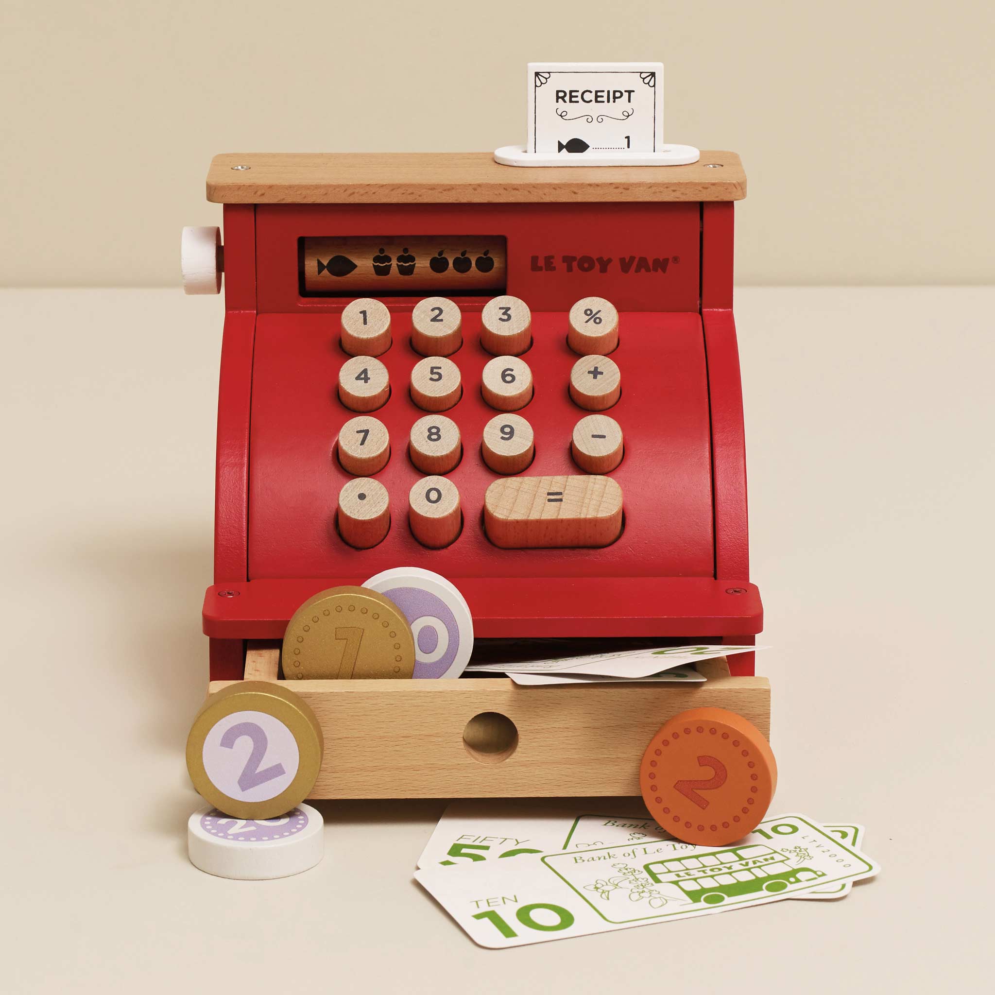 Toy cash register with wooden accents and digital display on a beige background