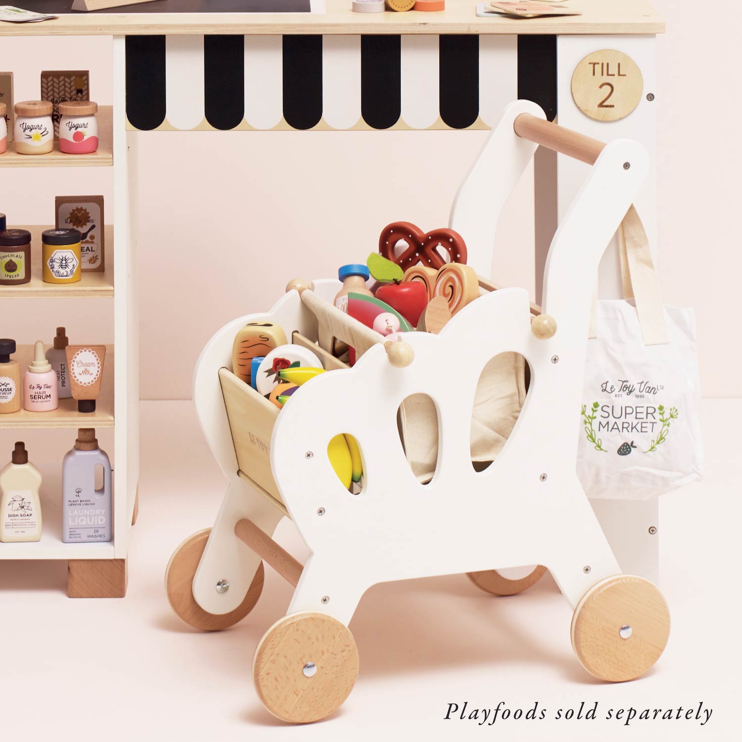 Wooden toy shopping cart with playfood items in a pretend market setting