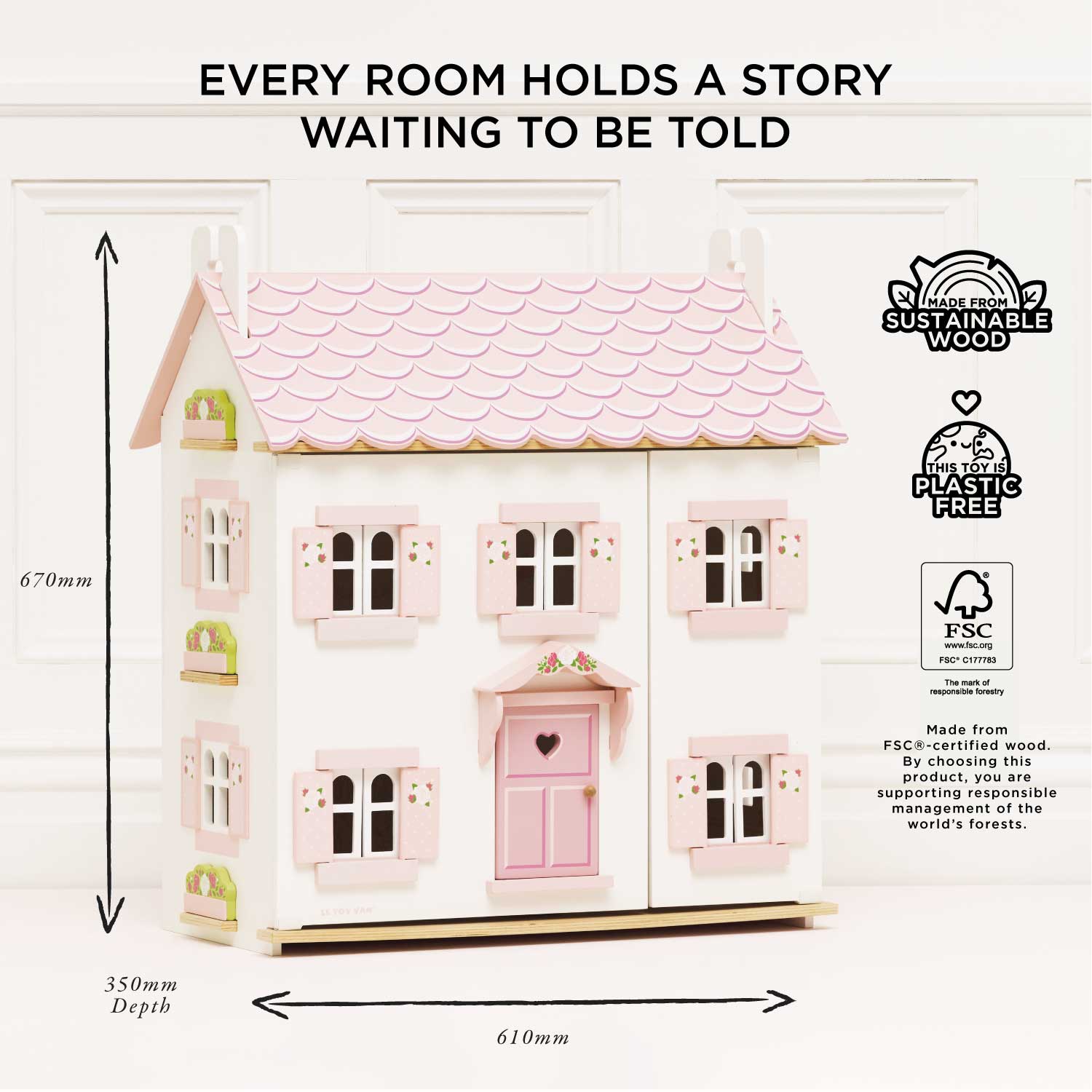 Pink dollhouse with dimensions and sustainability labels on a white background