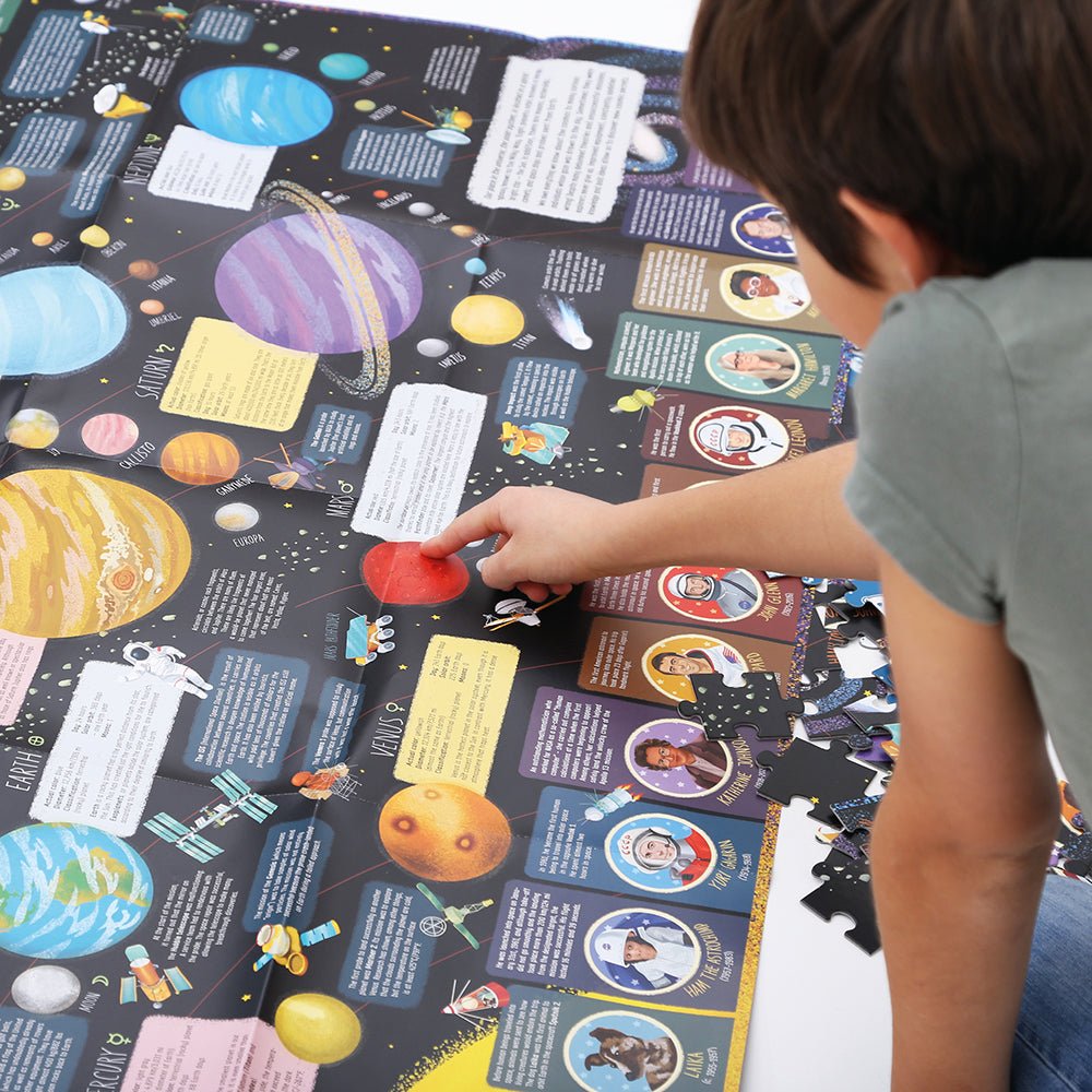 Child playing with a space-themed educational puzzle on a large mat.