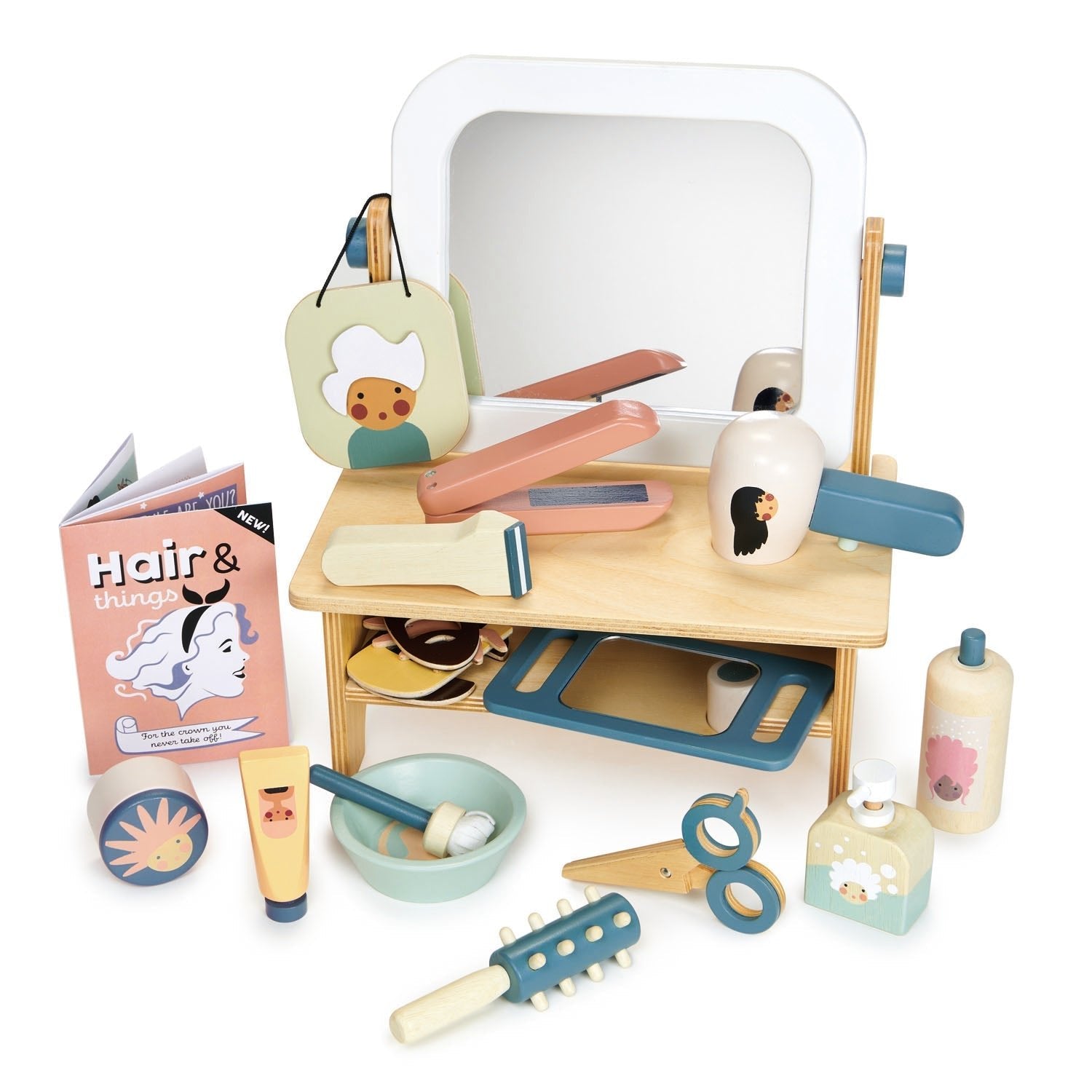Wooden toy hair salon set with various tools and a book on a white background