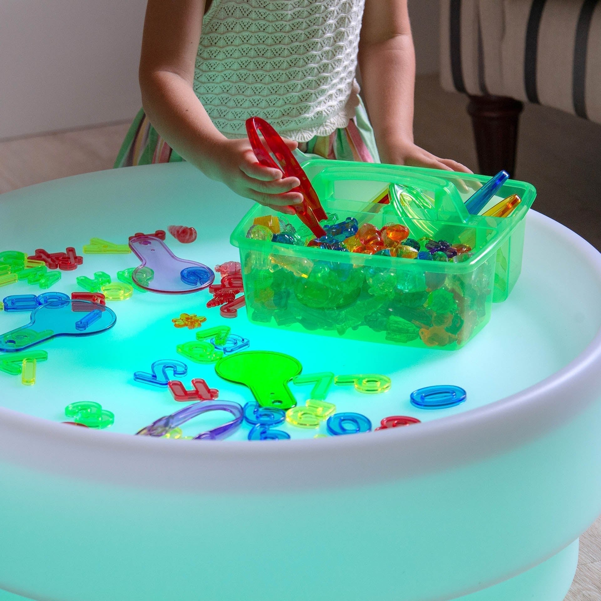 Child playing with colorful toys on a glowing table