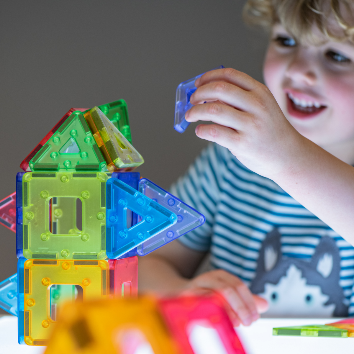 Child playing with colorful magnetic building blocks