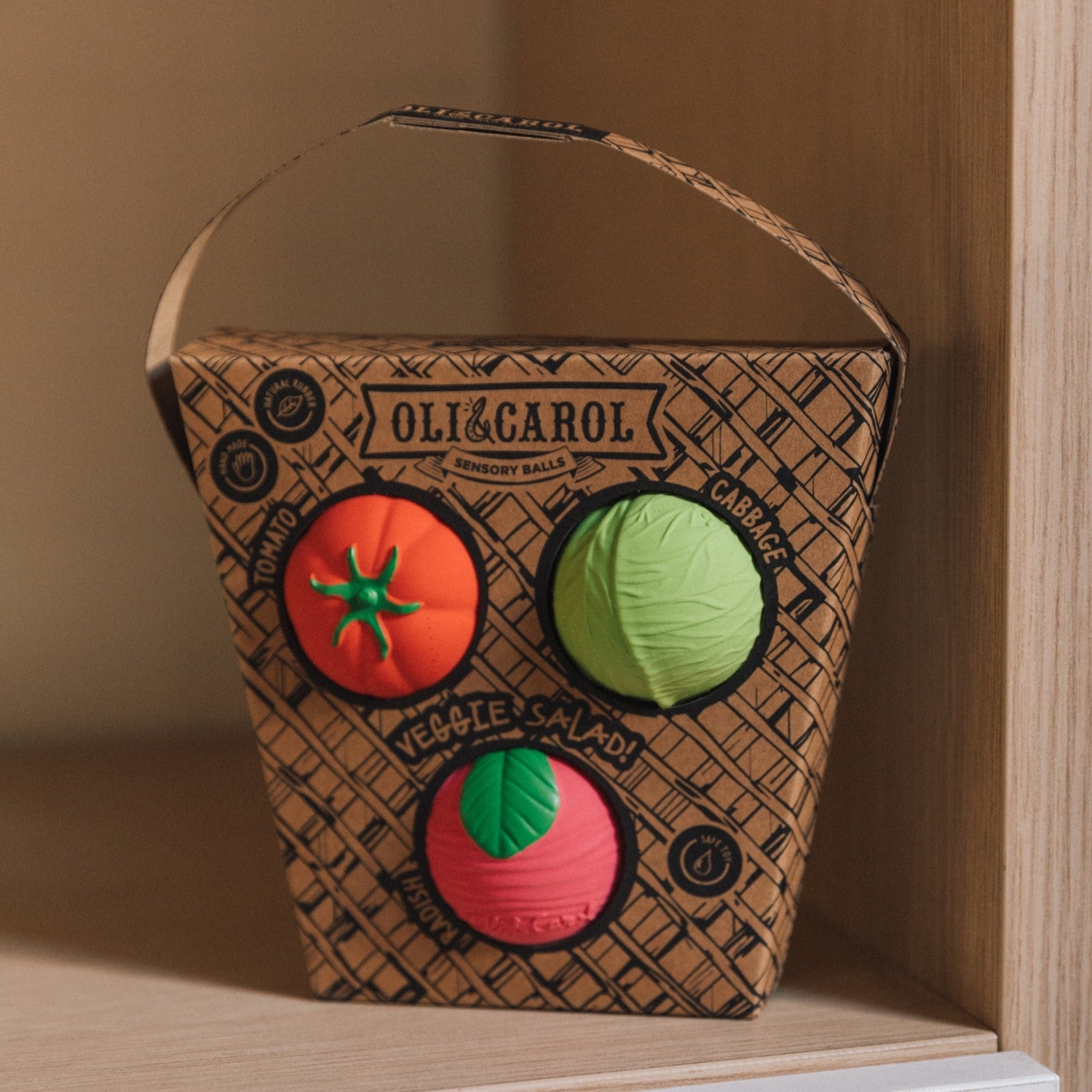 Cardboard box with toy vegetables on a wooden shelf