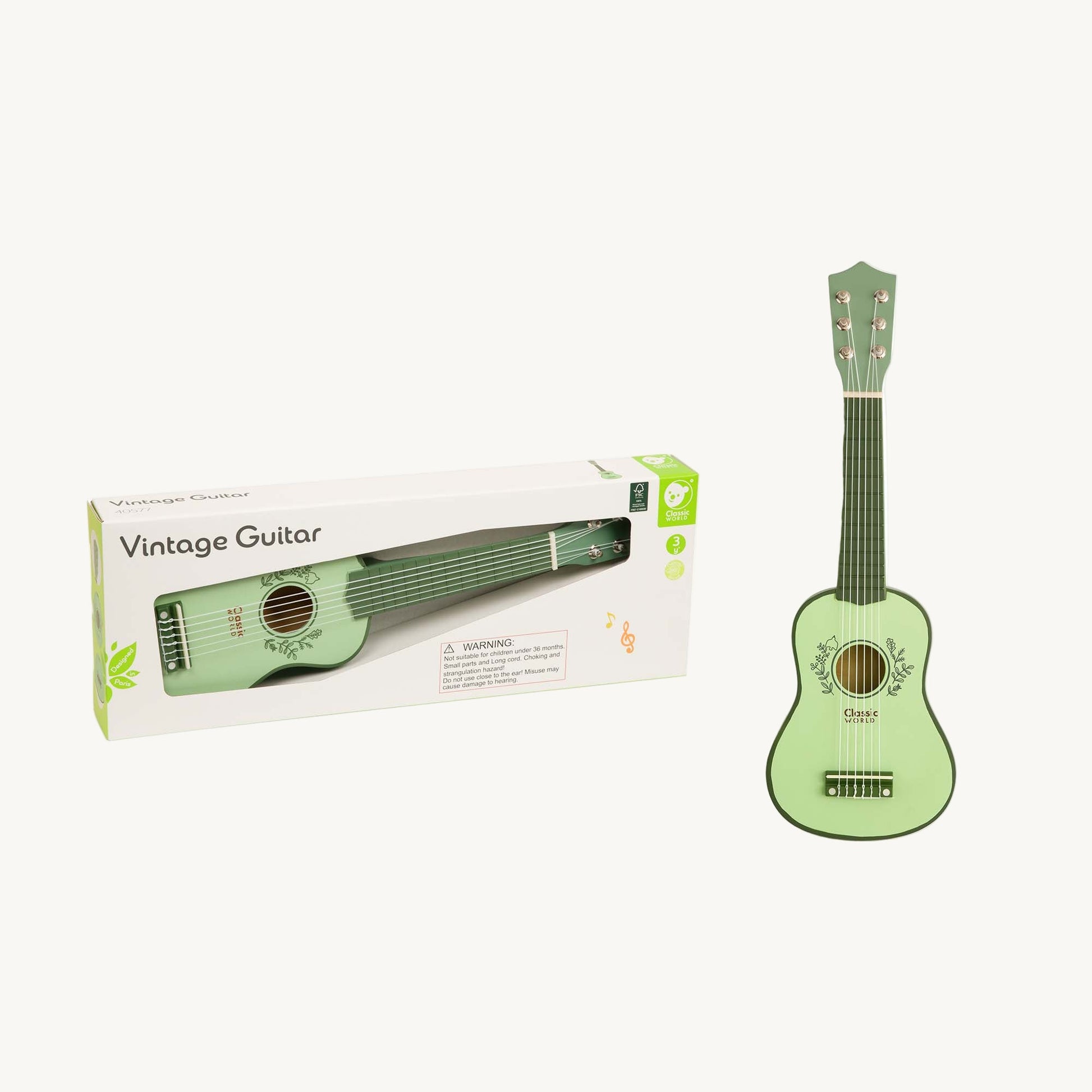Green toy guitar with packaging on a white background