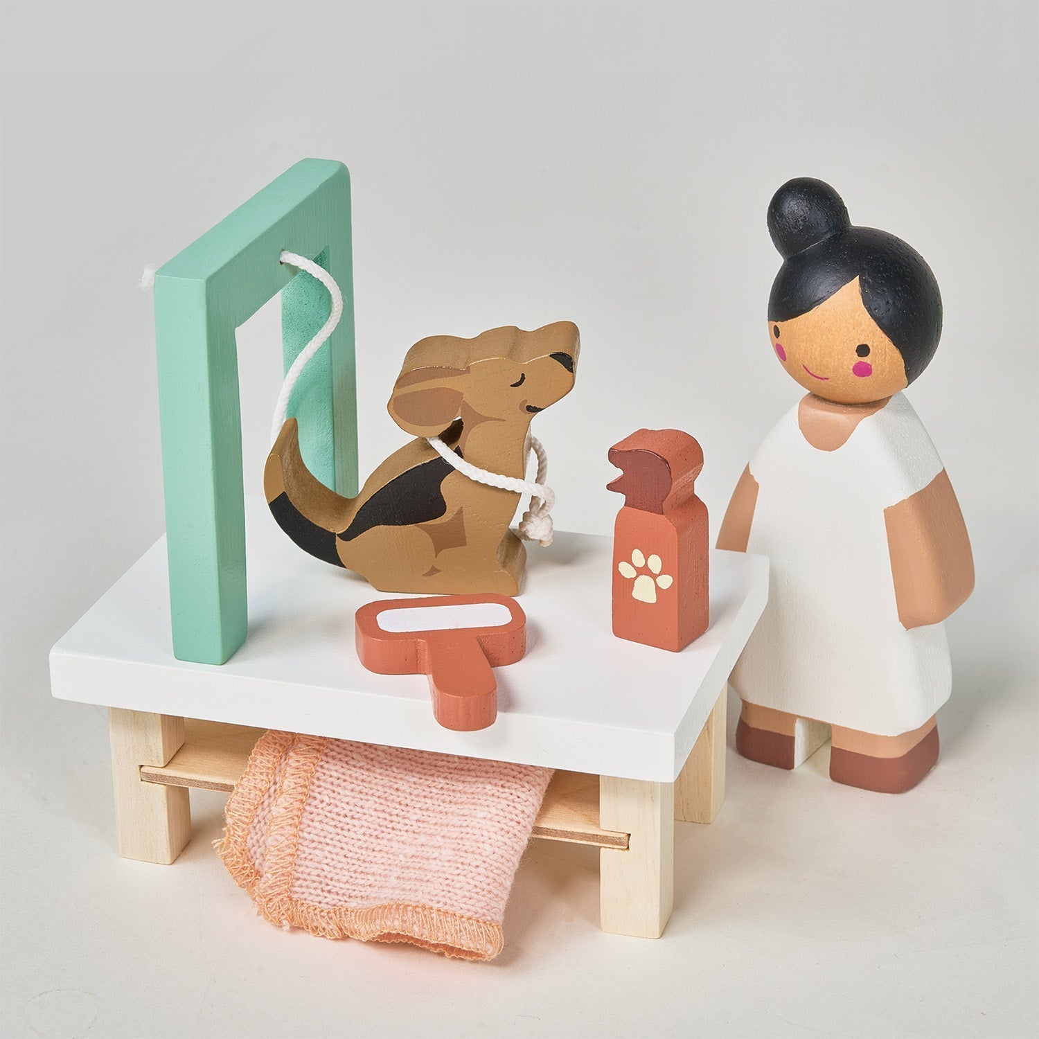 Wooden toy set with a dog, vet, and medical tools on a white background
