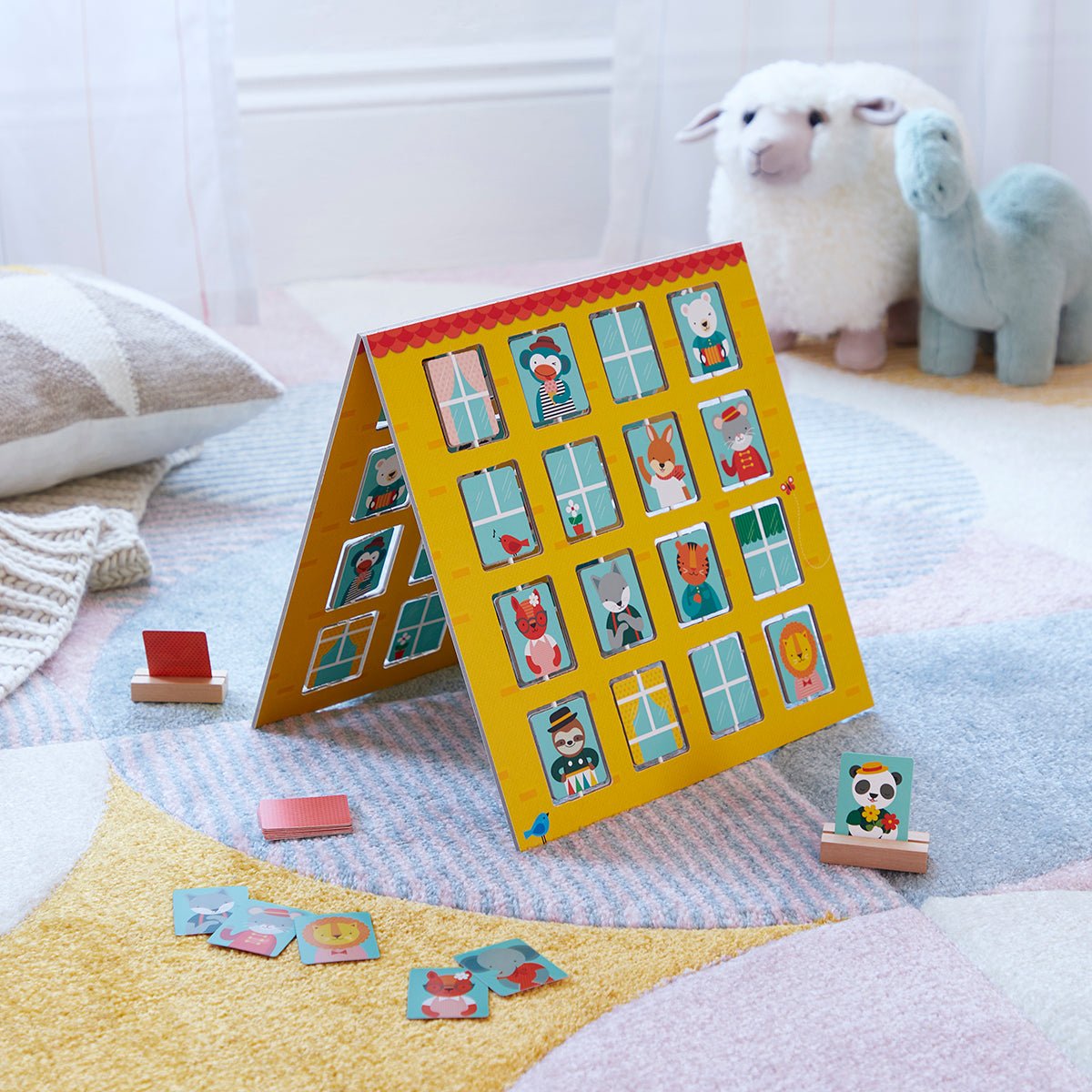 Children's puzzle with colorful illustrations on a stand, surrounded by plush toys on a soft surface.