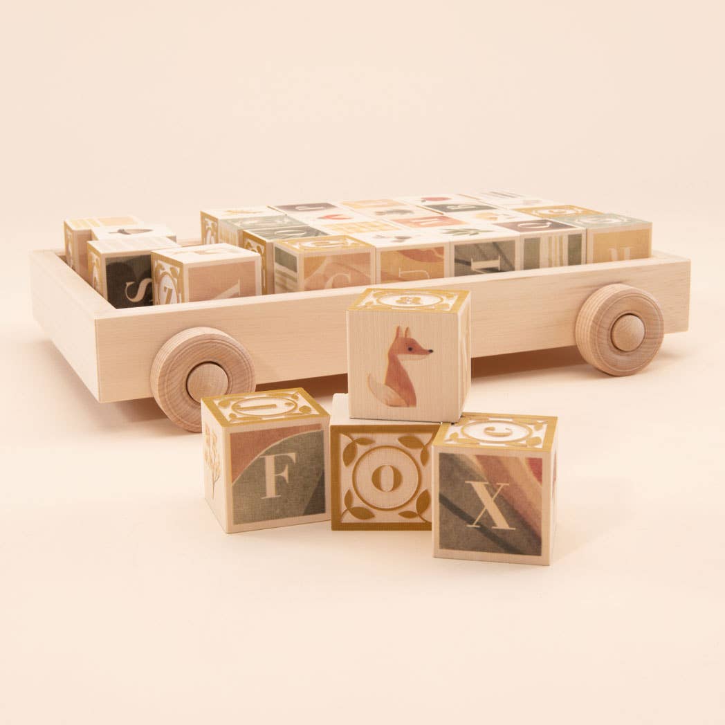 Wooden toy truck with alphabet blocks on a beige background