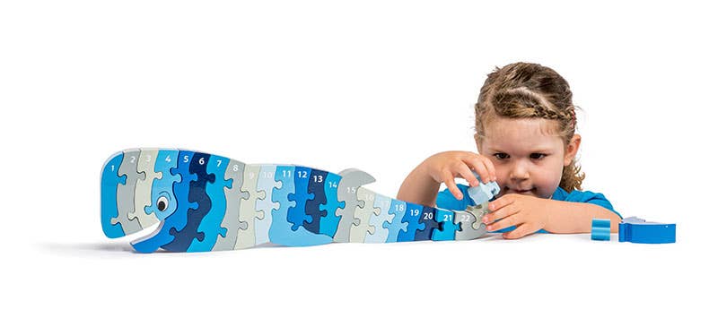 Child playing with a blue puzzle toy on a white background