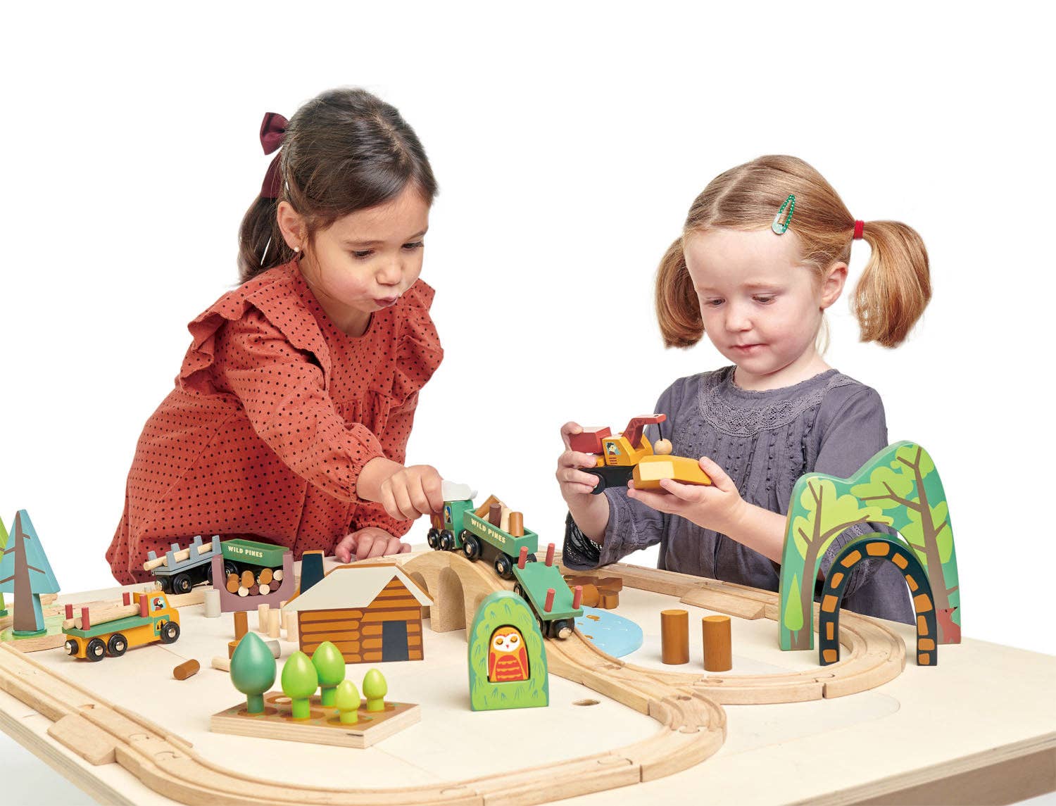 Two children playing with a wooden train set on a white background