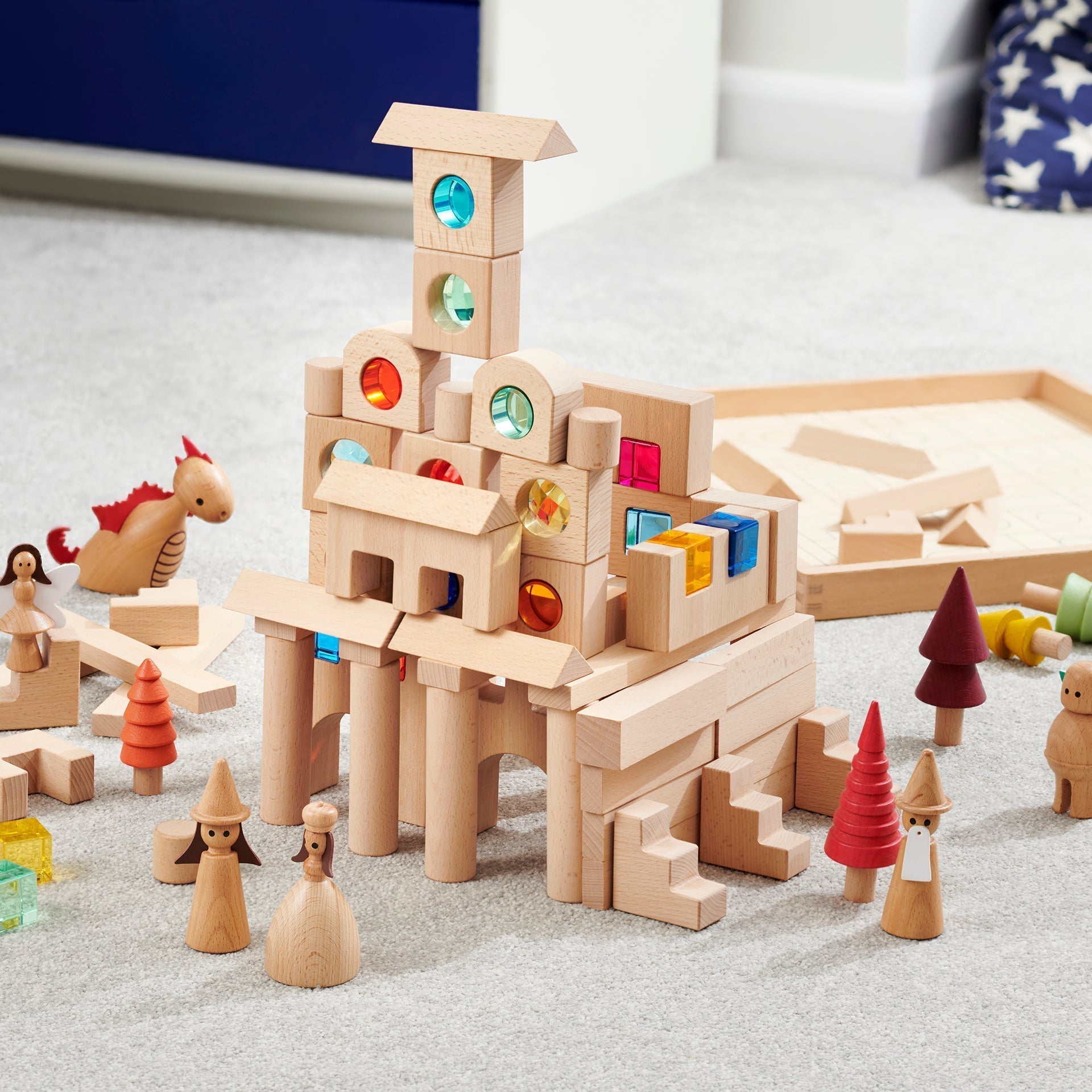 Wooden toy castle with colorful blocks on a light surface
