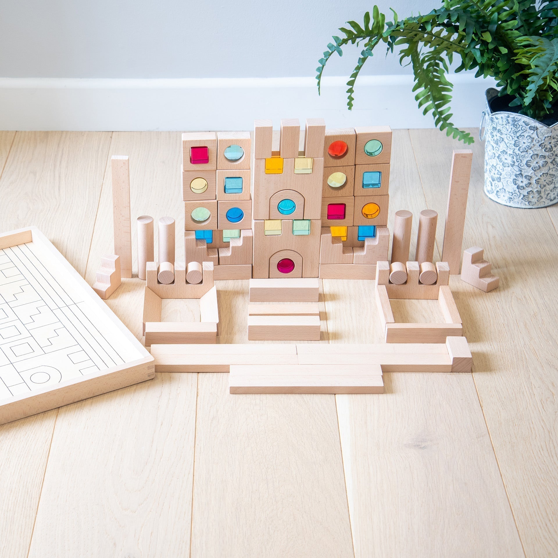 Wooden building blocks set with colorful circular pieces on a light wooden surface.