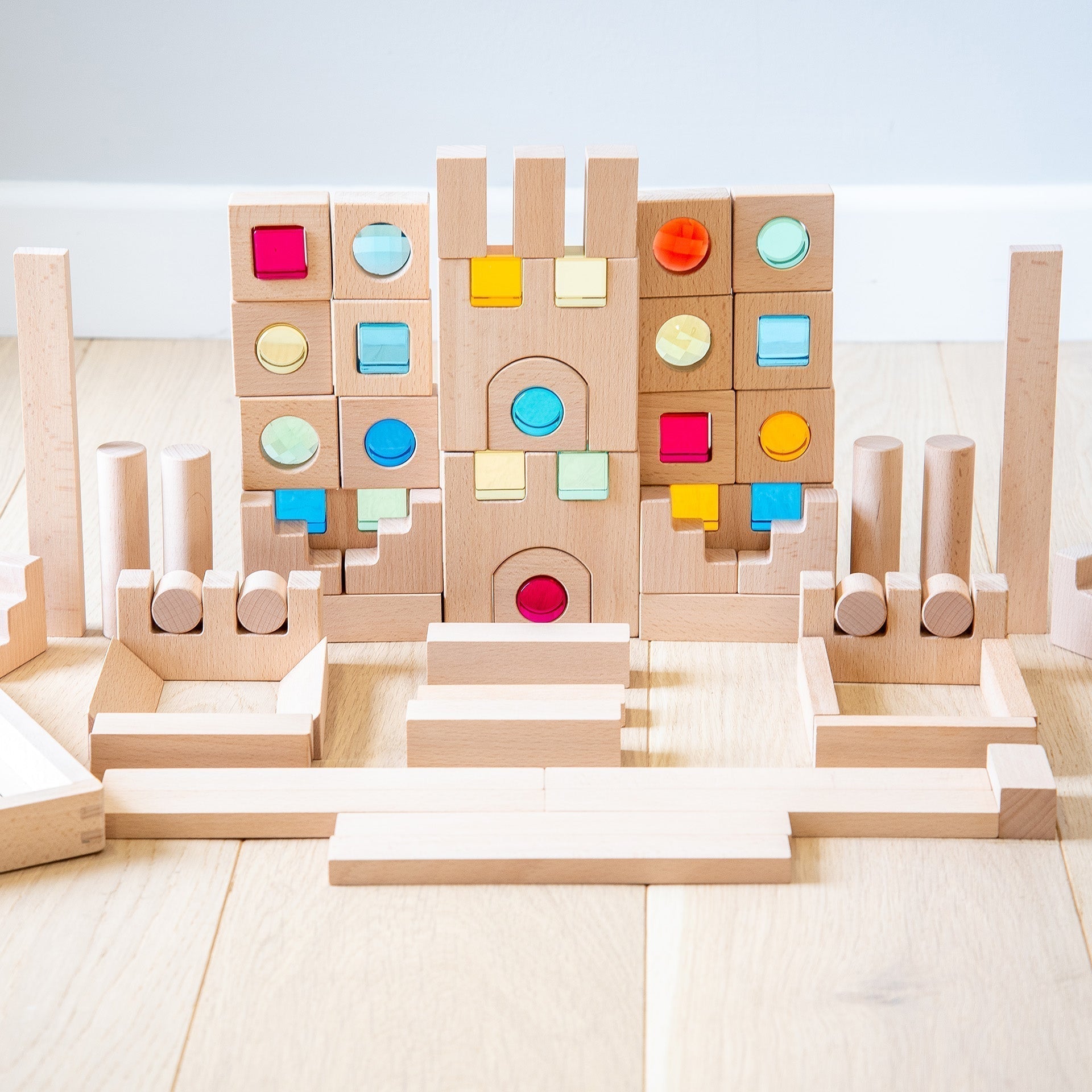 Wooden building blocks with colorful tops on a light wooden floor
