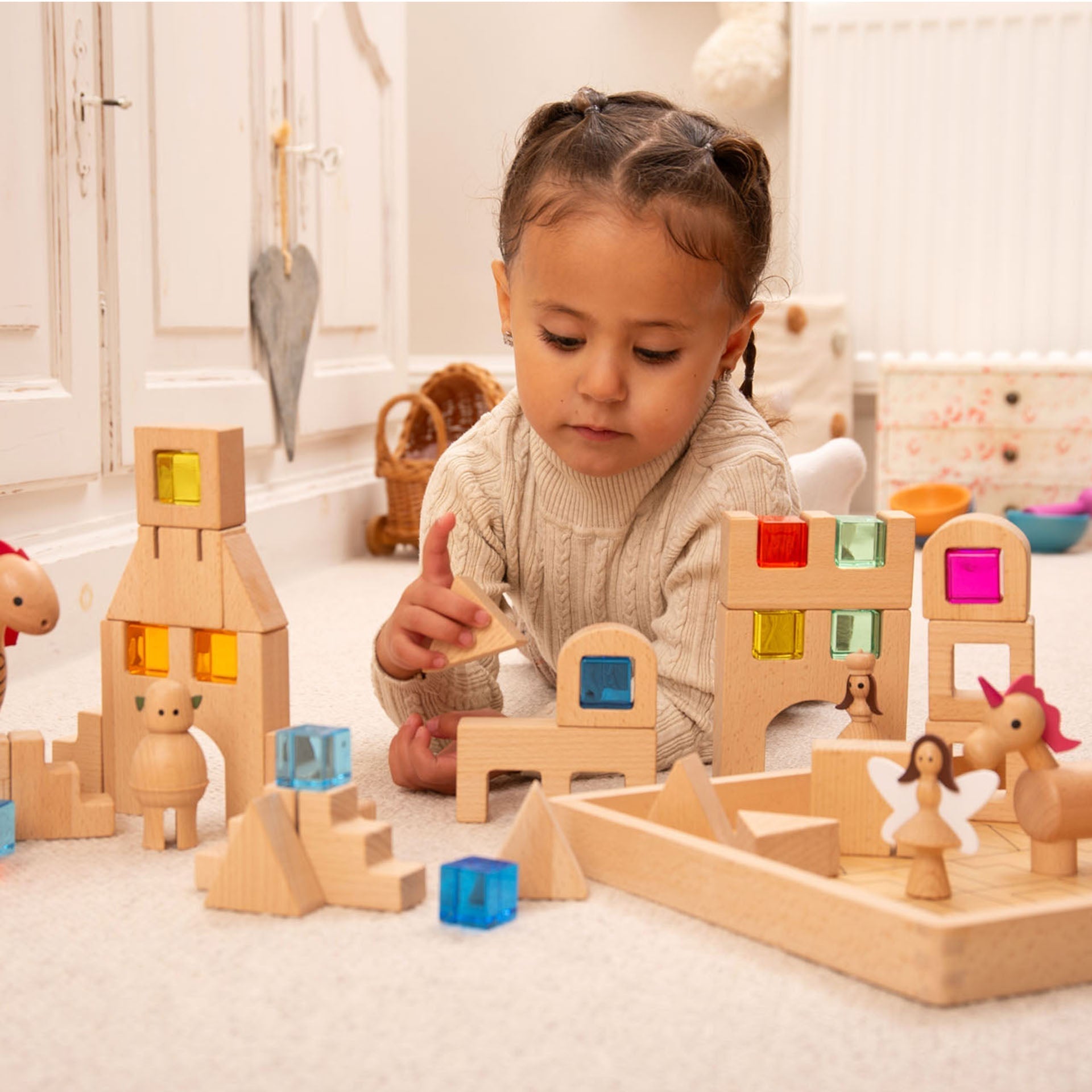 Child playing with wooden building blocks in a bright room