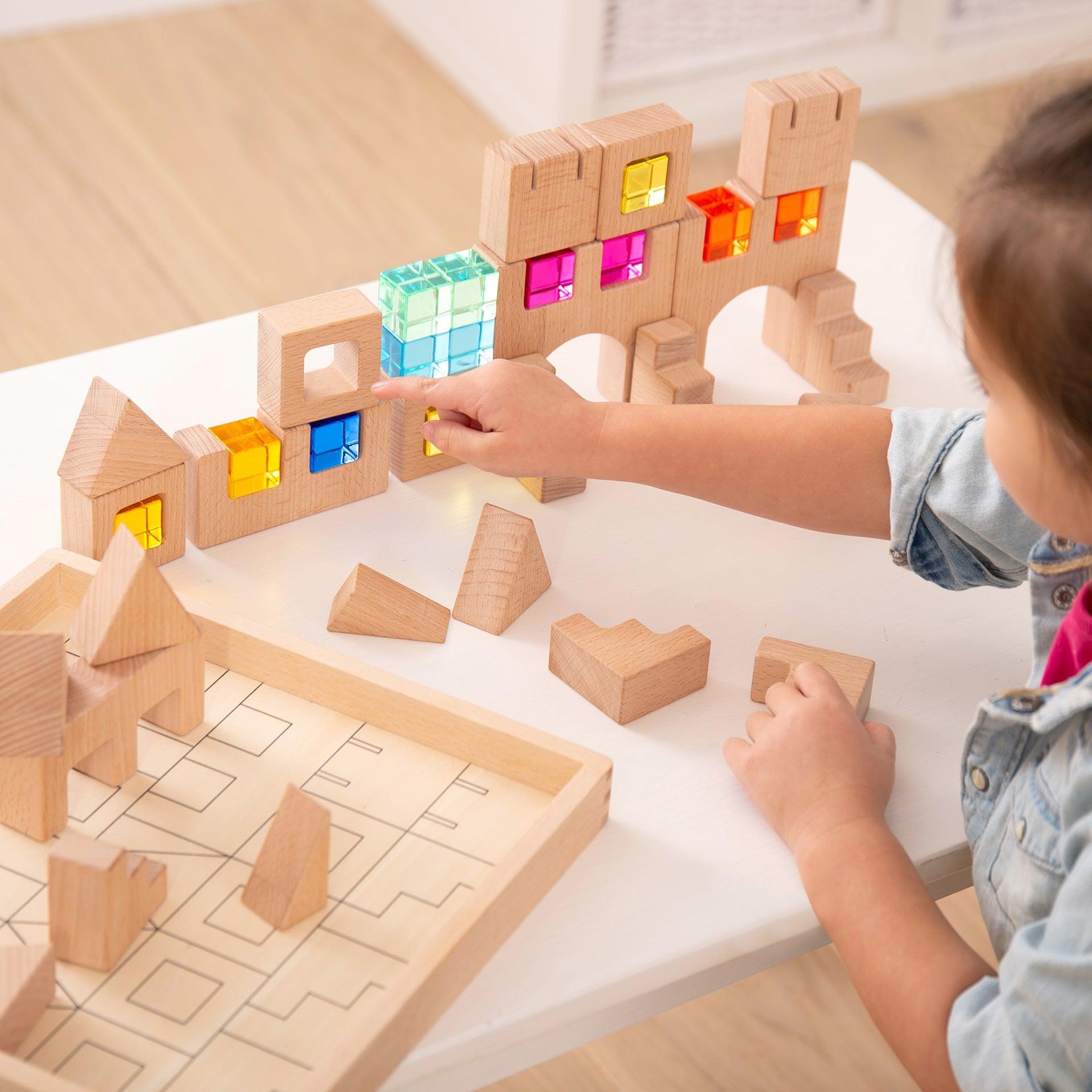 Child playing with wooden building blocks on a table