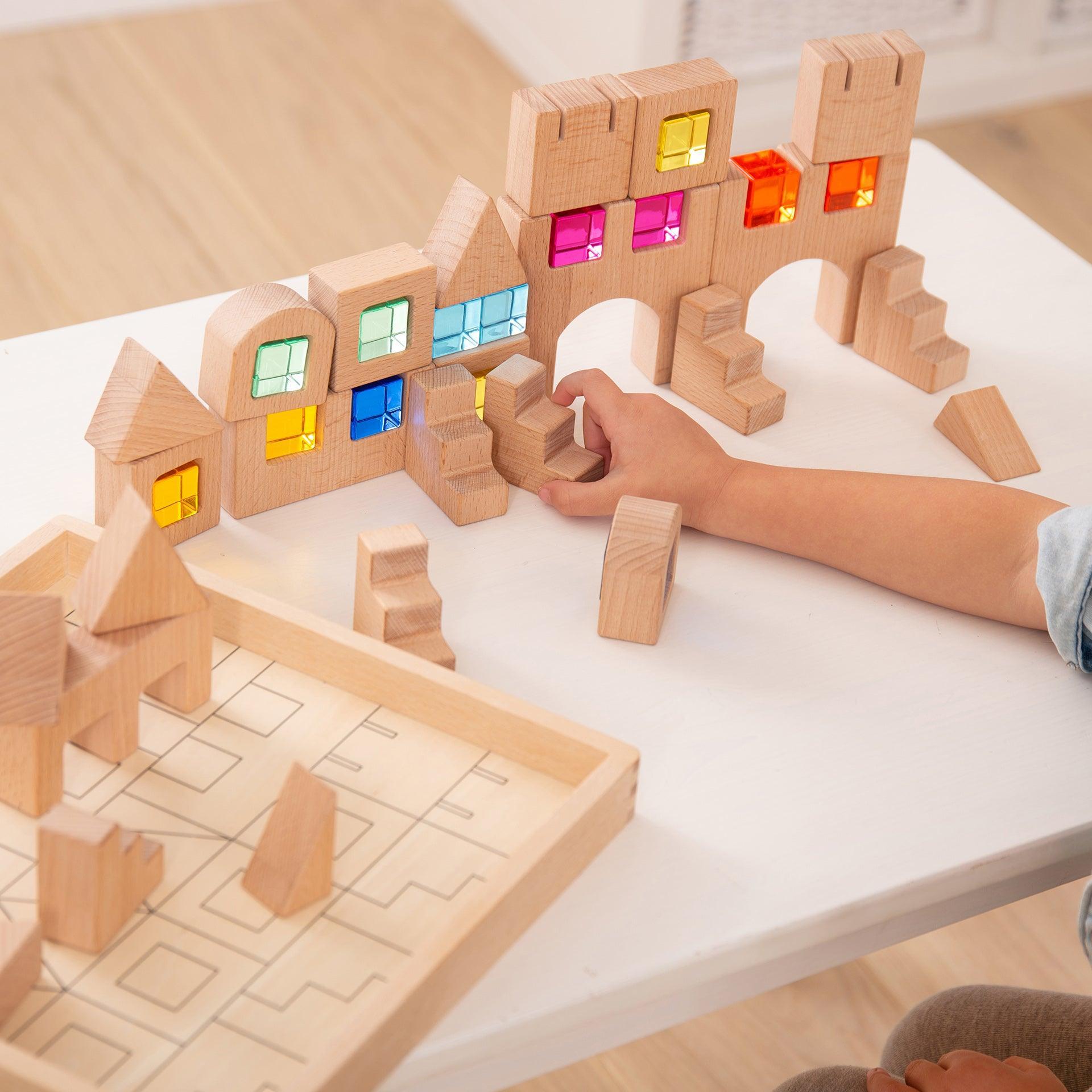 Wooden building blocks with colorful windows on a white surface