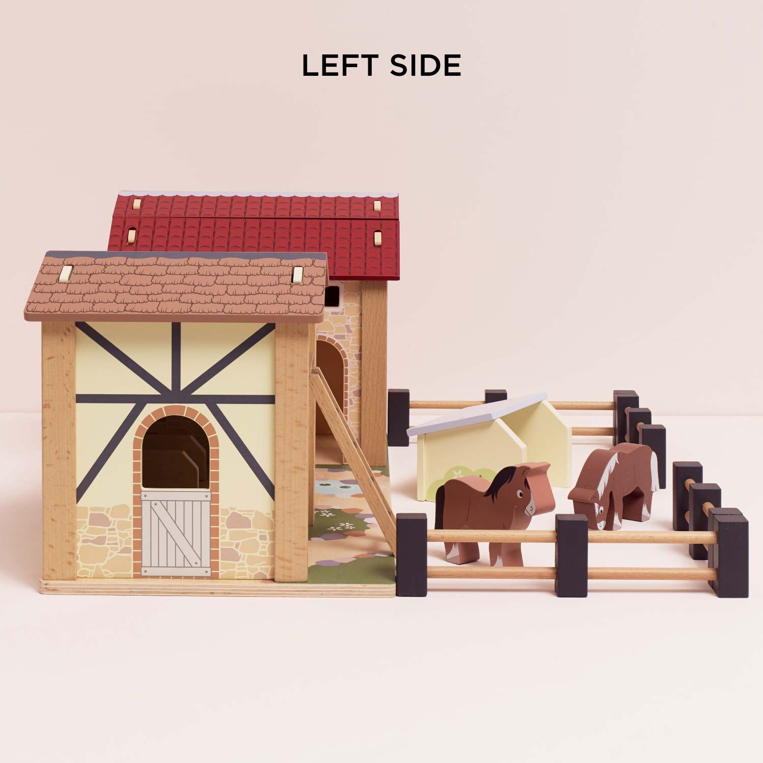 Toy stable with two horses on a beige background