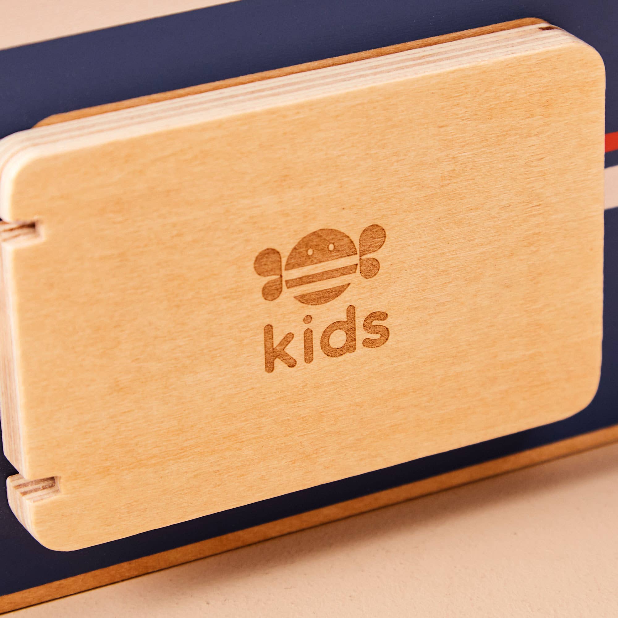 Wooden book with 'kids' engraving on a beige surface