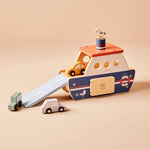 Wooden toy boat with a pull handle and small cars on a beige background