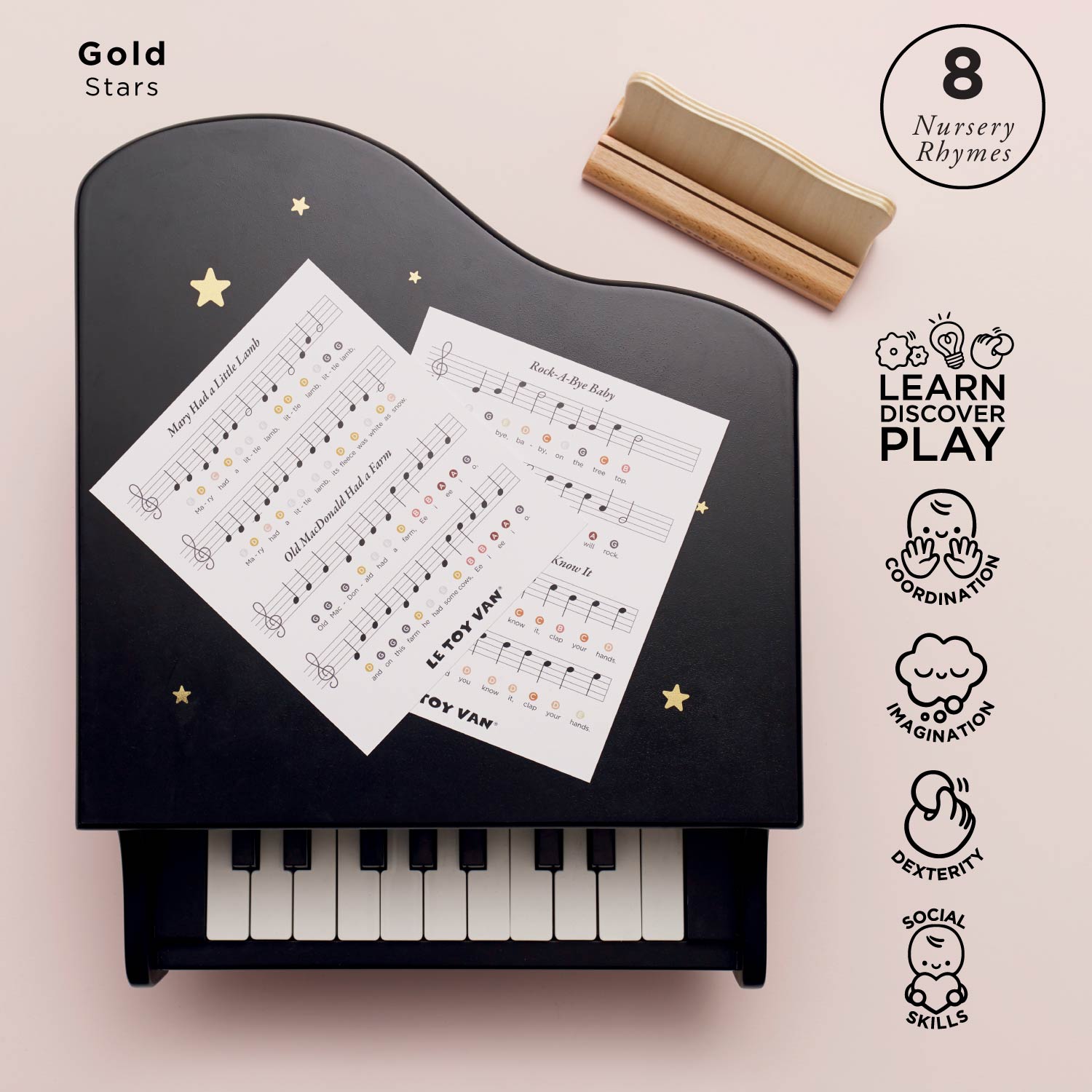 Black toy piano with music sheets and a wooden block on a pink background, featuring '8 Nursery Rhymes' branding.