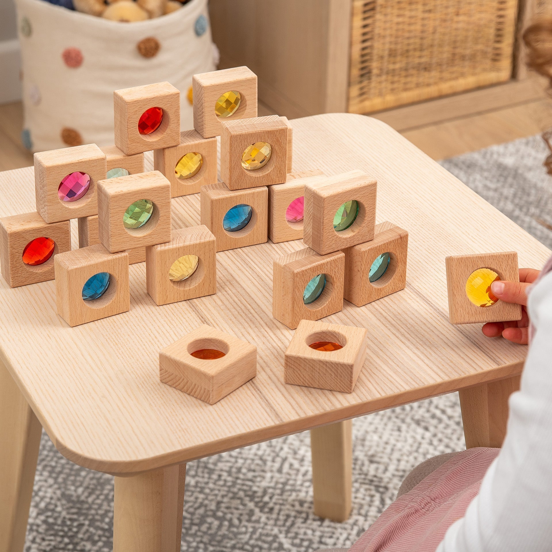 Wooden blocks with colorful recessed shapes on a wooden table