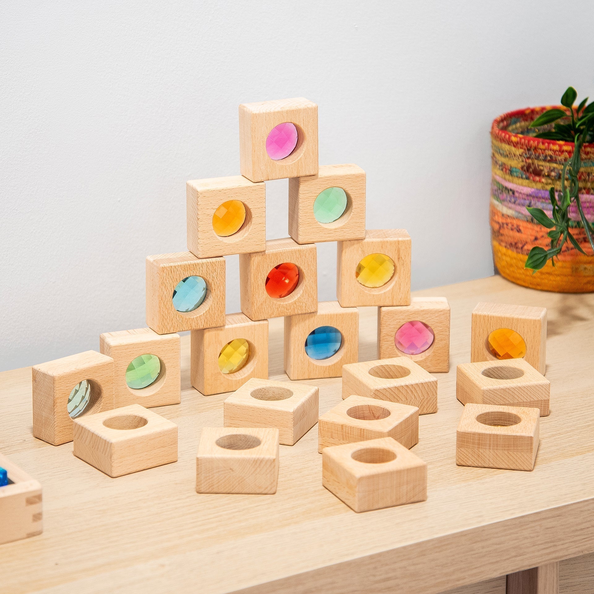 Stack of wooden blocks with colorful circular stickers on a light surface.