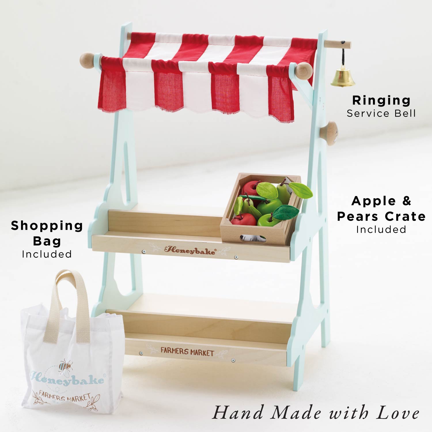 Wooden toy market stand with red and white striped canopy, shopping bag, and crate on a white background.