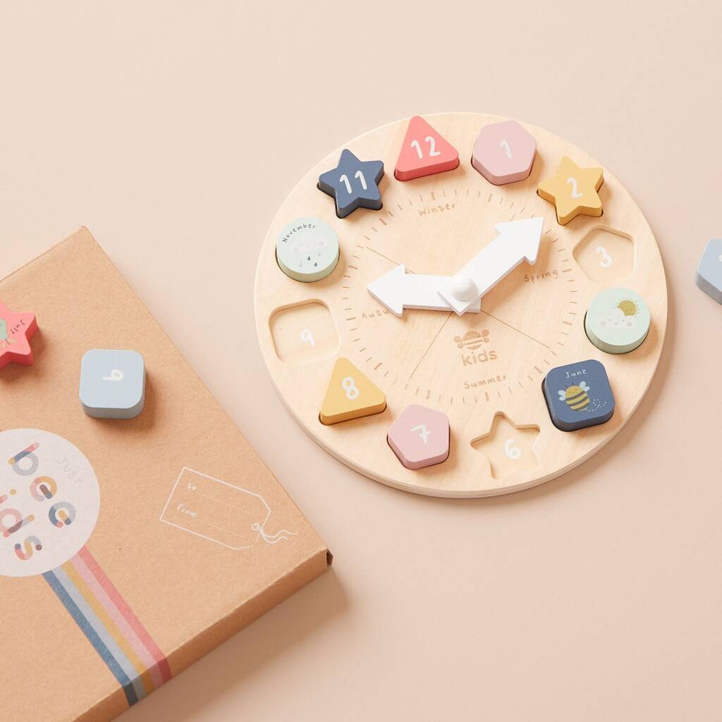 Children's wooden clock with colorful number and shape blocks on a beige background