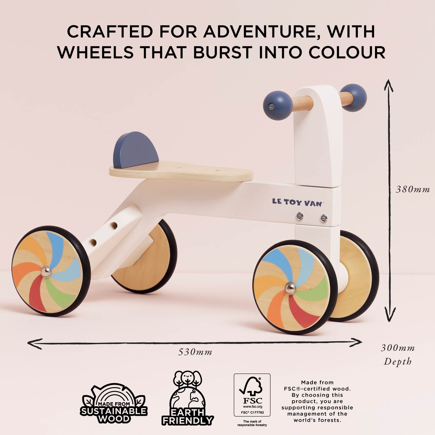 Children's balance bike with colorful wheels on a light pink background, featuring Le Toy Van branding.