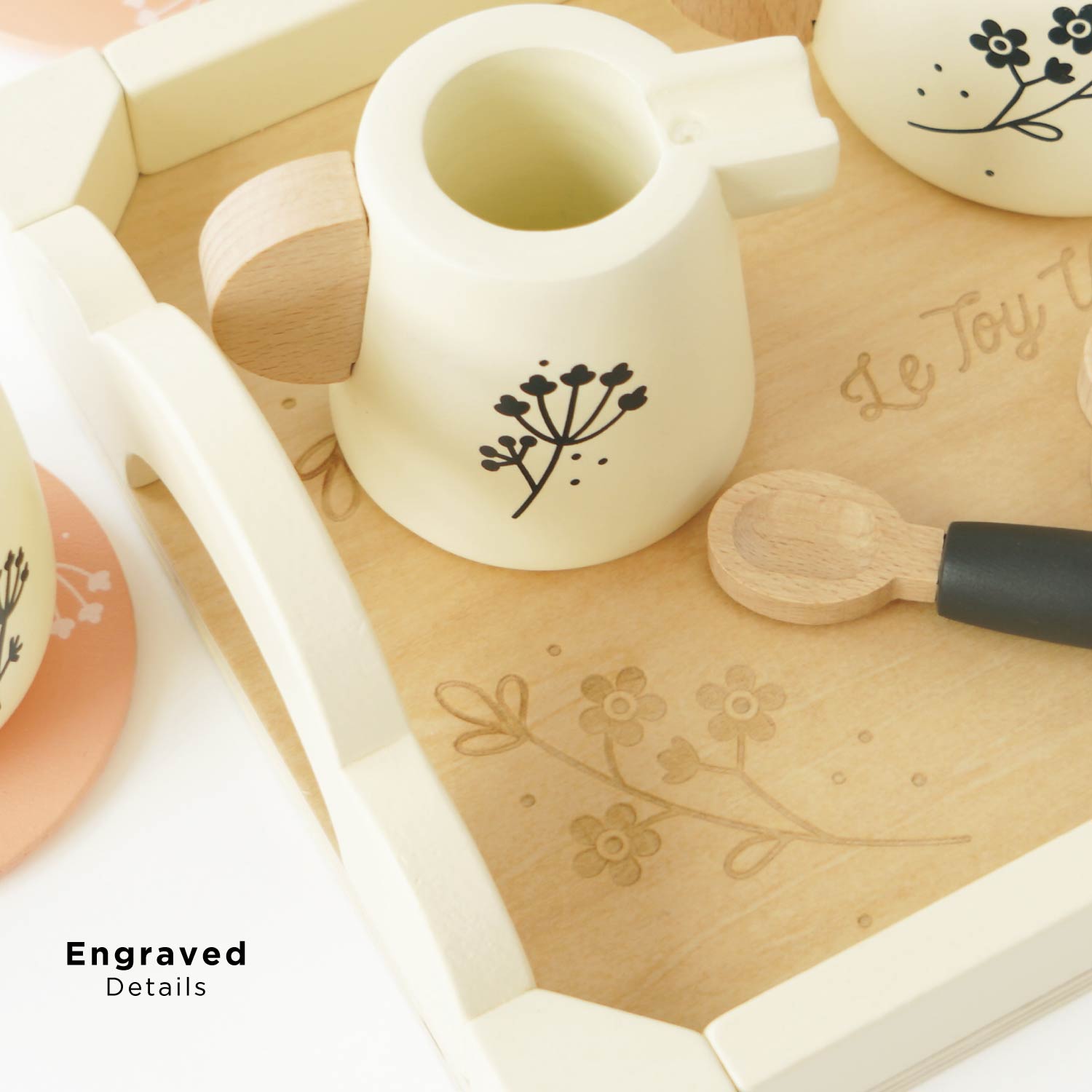 Wooden toy teapot with engraved details on a wooden tray, featuring the brand 'Le Toy Van'.