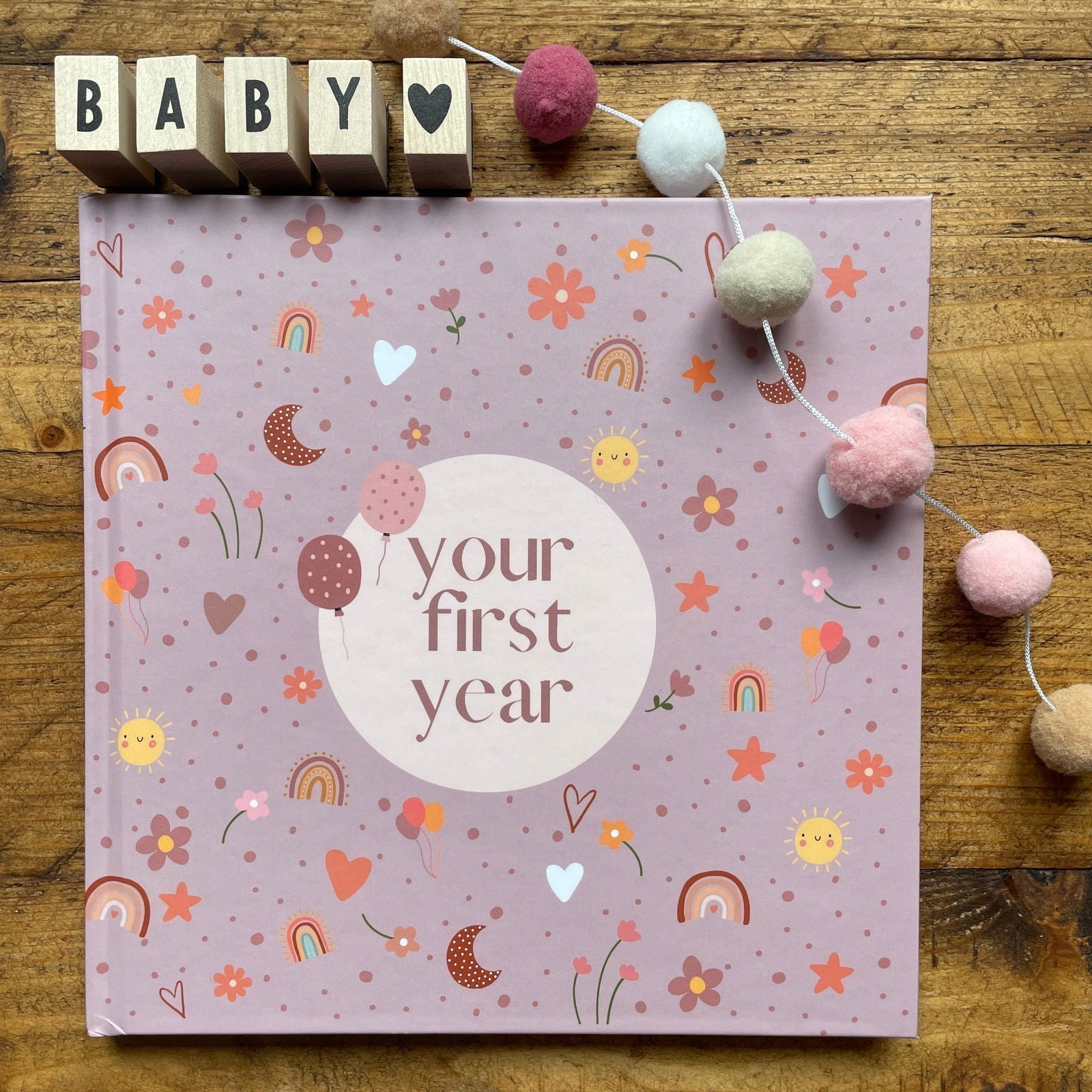 Book titled 'Your First Year' with decorative elements on a wooden surface