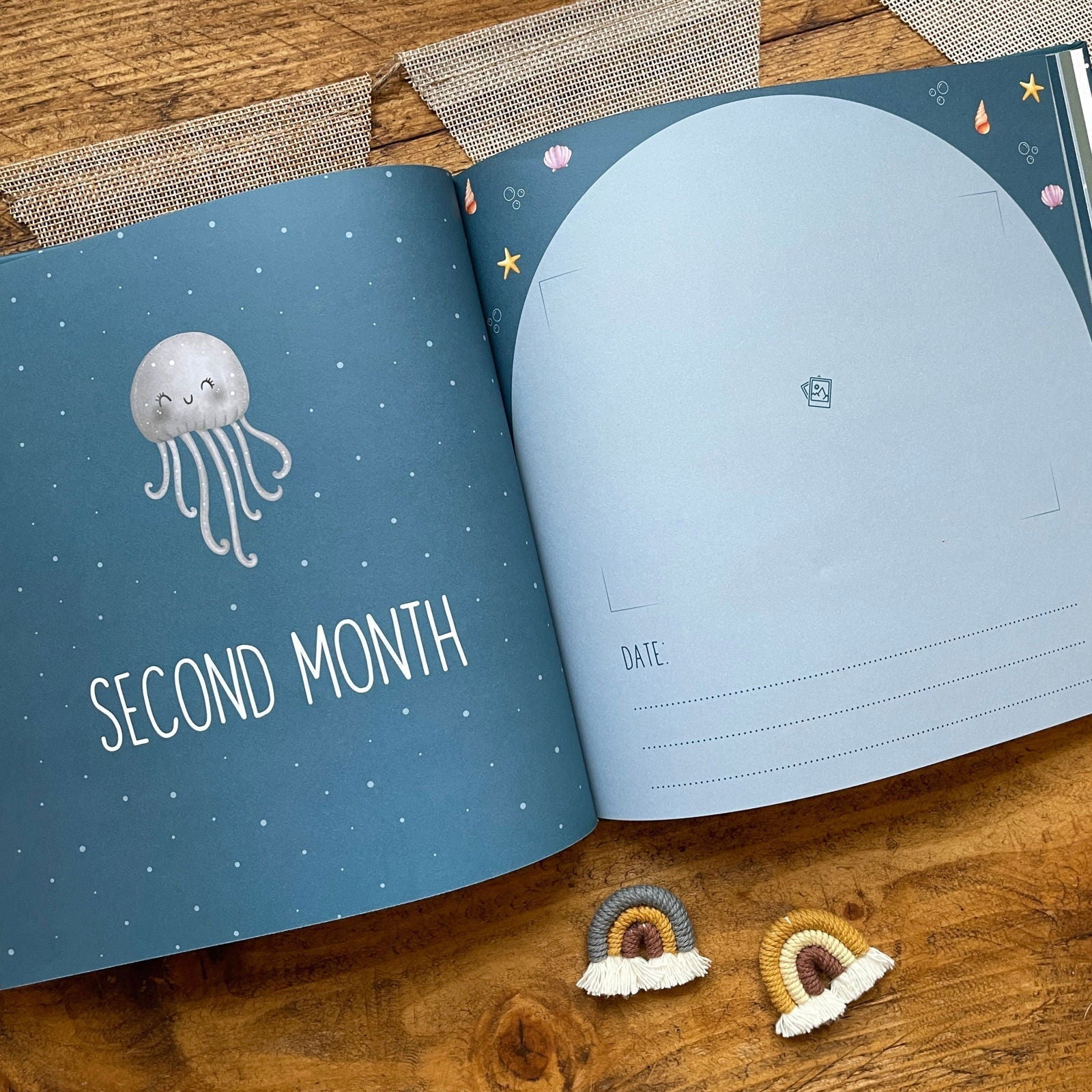 Open book with 'Second Month' and a jellyfish illustration on a wooden surface.