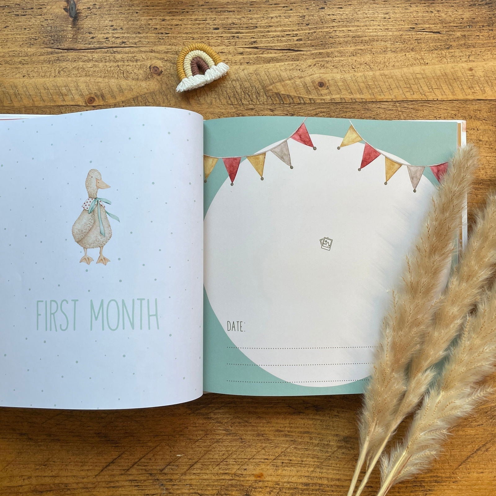 Open book with baby milestone tracker on a wooden surface