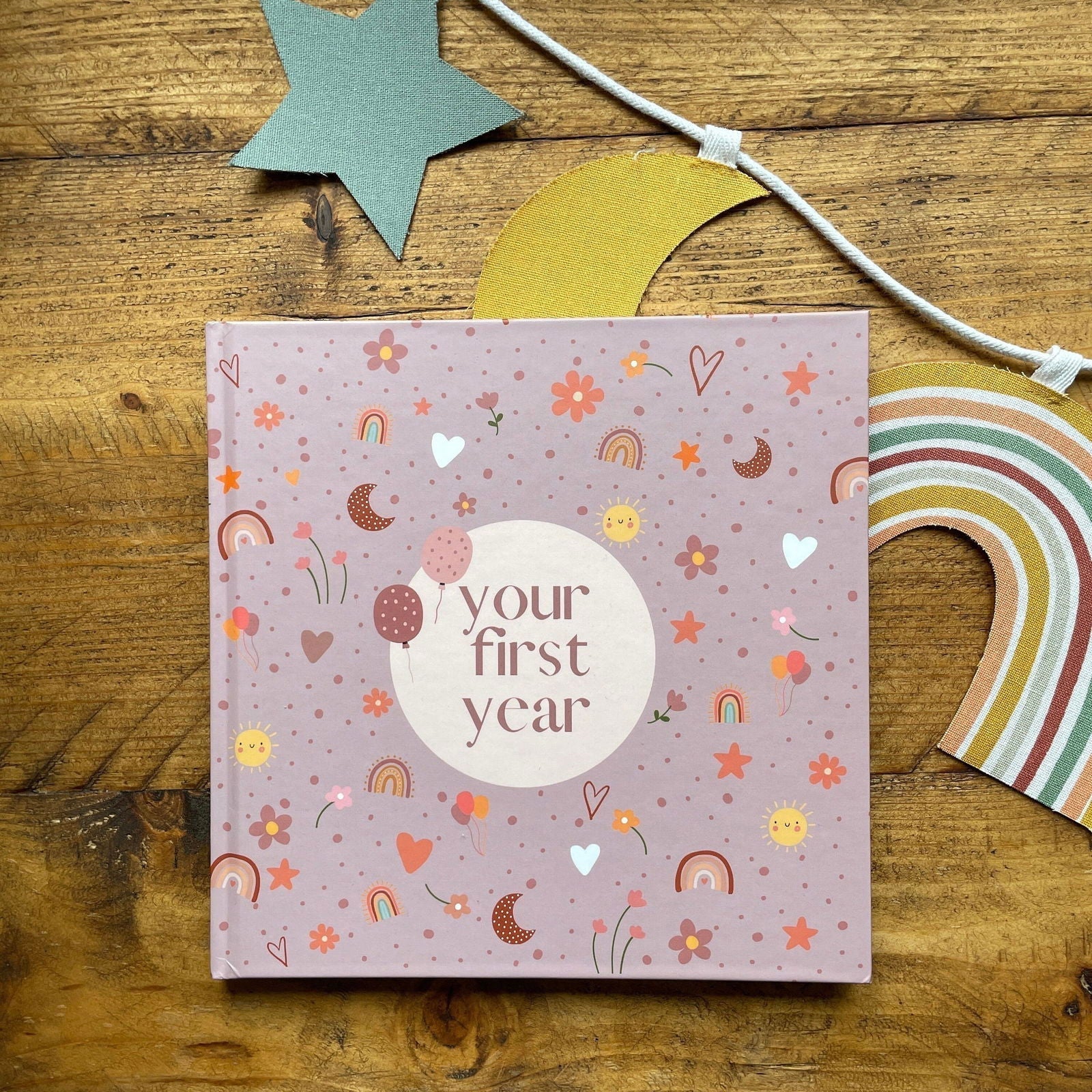 Book titled 'your first year' on a wooden surface with decorative items.